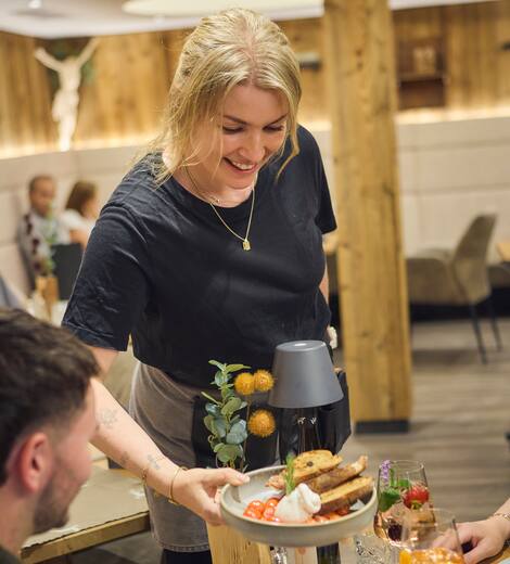 Dame serviert Essen an den Tisch