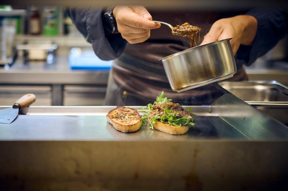 Chef plating a refined dish with great attention to detail
